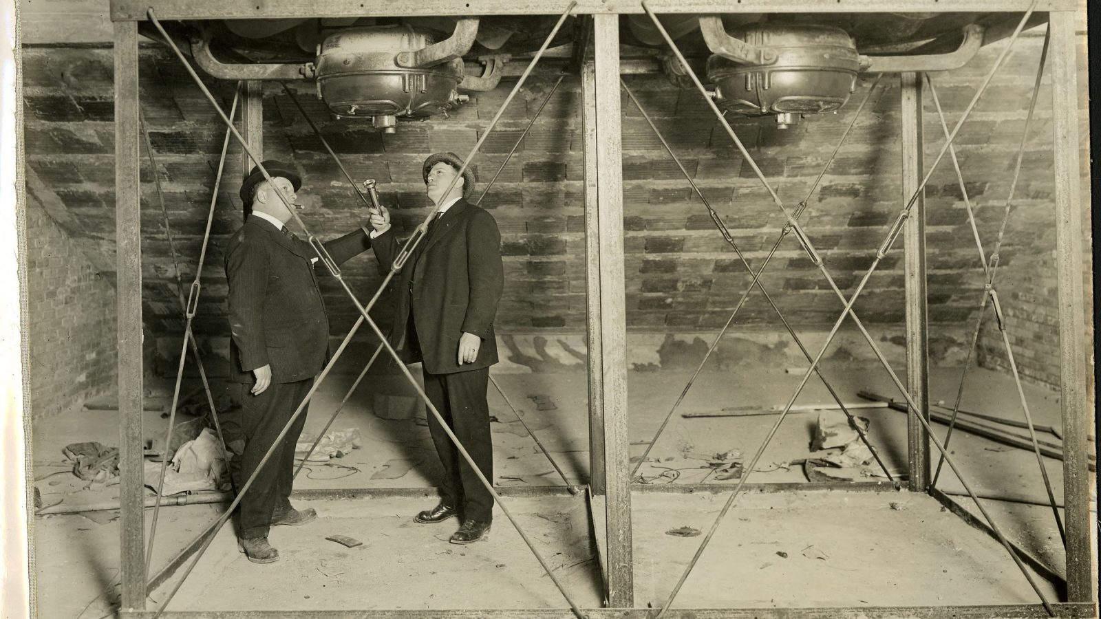 Imagen editorial para «Las bibliotecas quieren ayudar a leer las noticias, no solo a encontrarlas»: Two men inspect the installation of attic exhaust fans.